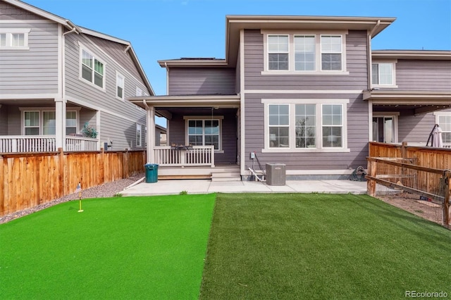 back of property featuring central AC unit, fence, a patio area, and a lawn