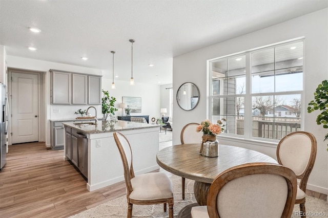 dining area with baseboards, light wood finished floors, and recessed lighting