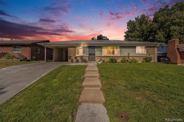 ranch-style home featuring a yard and a carport