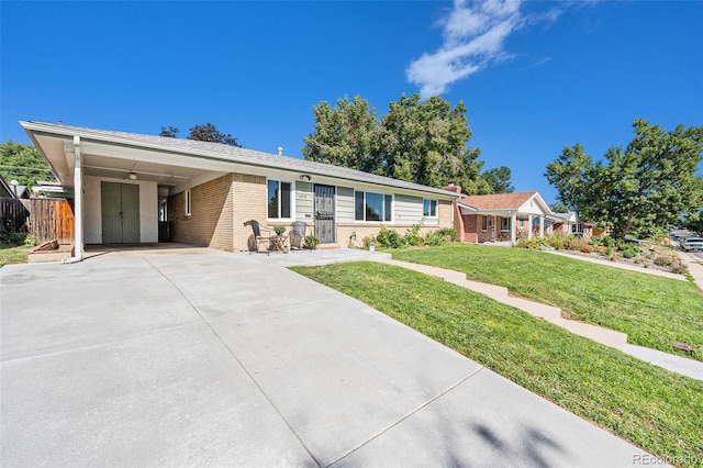 ranch-style home featuring a carport and a front lawn