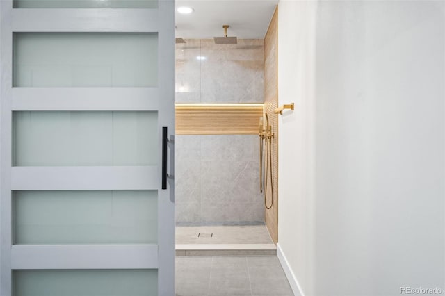 bathroom featuring tile patterned flooring and tiled shower