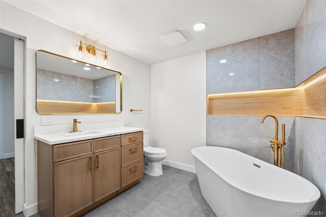 bathroom featuring vanity, tile walls, tile patterned flooring, toilet, and a tub