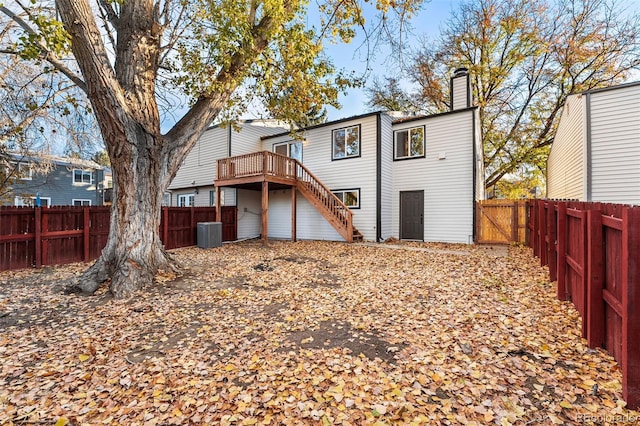 back of house featuring central AC unit and a deck