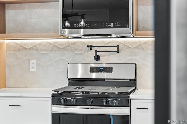 kitchen with white cabinetry, backsplash, and appliances with stainless steel finishes