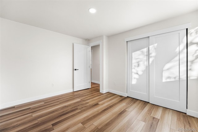 unfurnished bedroom featuring light hardwood / wood-style floors and a closet