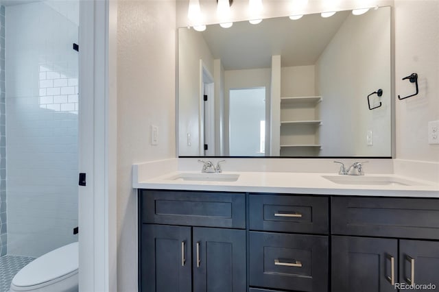 bathroom featuring toilet, vanity, and tiled shower