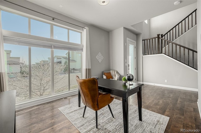 office area with visible vents, baseboards, and wood finished floors