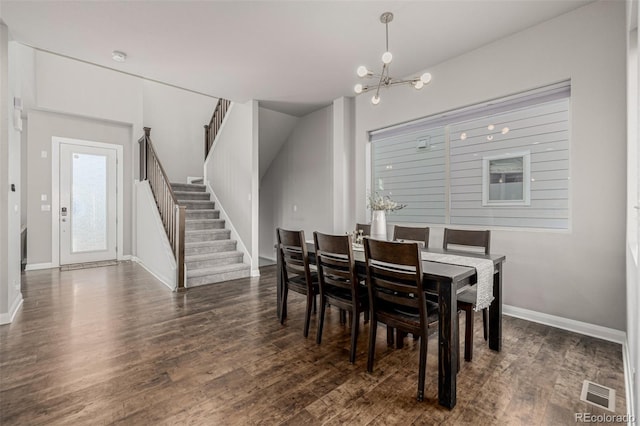 dining room featuring visible vents, an inviting chandelier, dark wood finished floors, and stairs