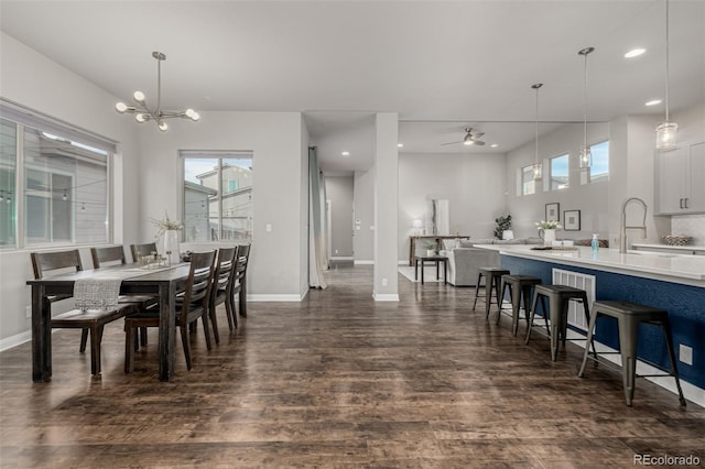 dining space with recessed lighting, baseboards, dark wood-style floors, and ceiling fan with notable chandelier