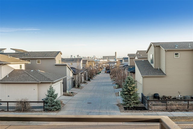 view of community featuring a view of city, fence, a garage, and driveway