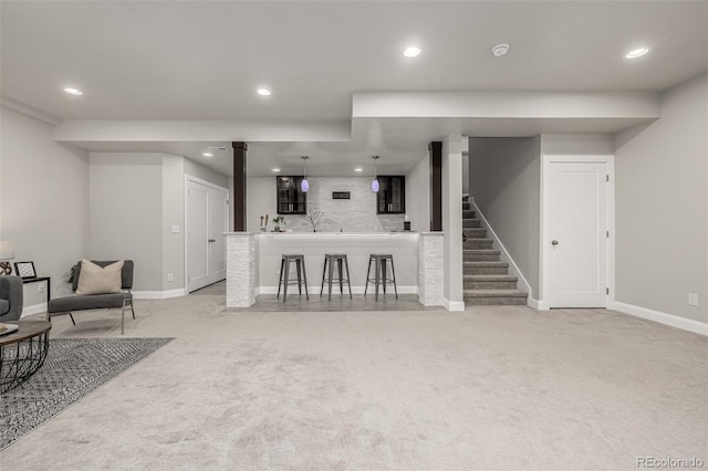 living room featuring baseboards, recessed lighting, stairs, indoor wet bar, and light carpet