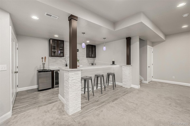 kitchen with a breakfast bar area, visible vents, wine cooler, light carpet, and tasteful backsplash