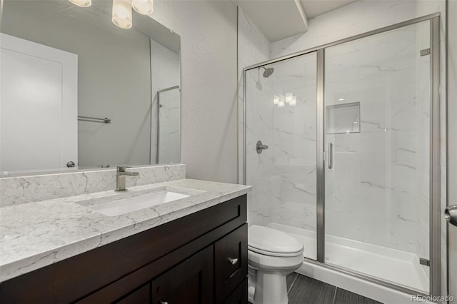 bathroom with vanity, toilet, and a marble finish shower