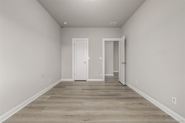 unfurnished bedroom with light wood-type flooring, baseboards, and visible vents