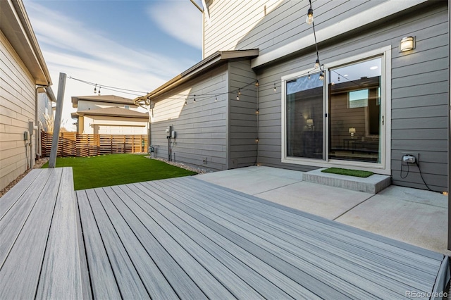 deck with a yard, a patio, and fence