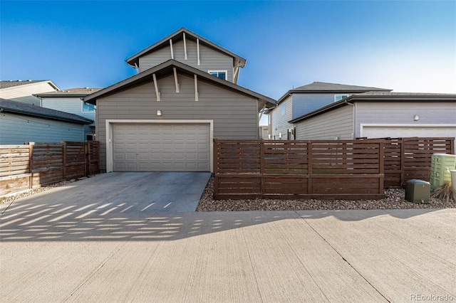 view of front of house featuring fence, a garage, and driveway