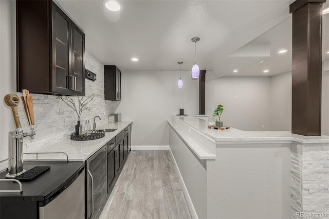 kitchen featuring backsplash, recessed lighting, light wood-style flooring, and baseboards