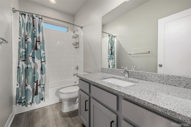 bathroom with vanity, wood finished floors, shower / tub combo, and toilet