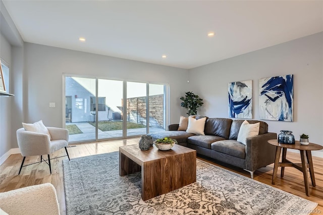 living area with light wood-style floors, baseboards, and recessed lighting