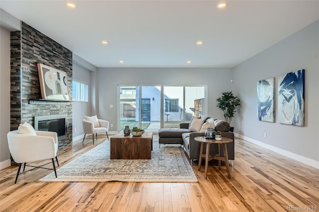 living room with a fireplace, baseboards, wood finished floors, and recessed lighting