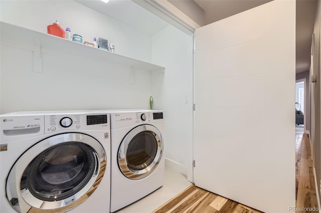 laundry area featuring laundry area, light wood-style flooring, and washer and clothes dryer