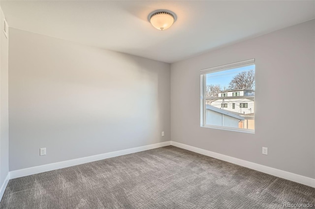 unfurnished room with carpet flooring and baseboards