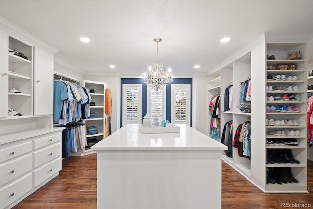 spacious closet featuring an inviting chandelier and dark wood-type flooring