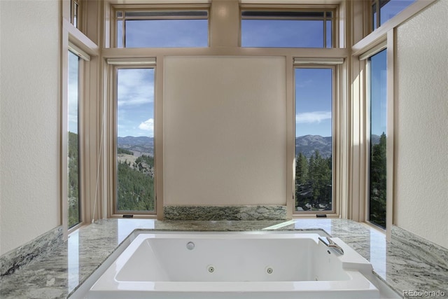 180 Outpost Ln, Evergreen, CO 80439 - full bath featuring a mountain view, a textured wall, and a tub with jets