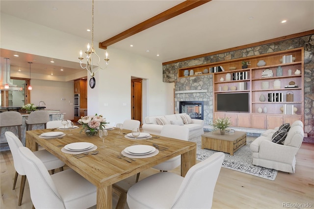 180 Outpost Ln, Evergreen, CO 80439 - dining space with light wood-style flooring, a chandelier, a multi sided fireplace, beam ceiling, and recessed lighting