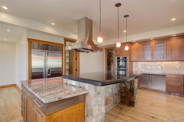 180 Outpost Ln, Evergreen, CO 80439 - kitchen with appliances with stainless steel finishes, island exhaust hood, a large island, light wood-style floors, and recessed lighting