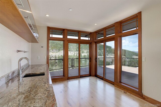 180 Outpost Ln, Evergreen, CO 80439 - kitchen with a sink, light wood-style floors, light stone countertops, and recessed lighting