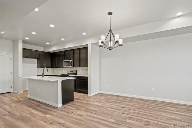 kitchen featuring a sink, stainless steel appliances, light wood-style floors, and light countertops