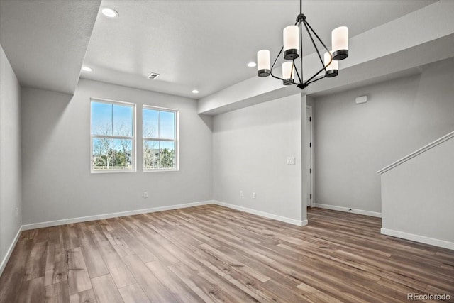interior space featuring visible vents, wood finished floors, recessed lighting, an inviting chandelier, and baseboards