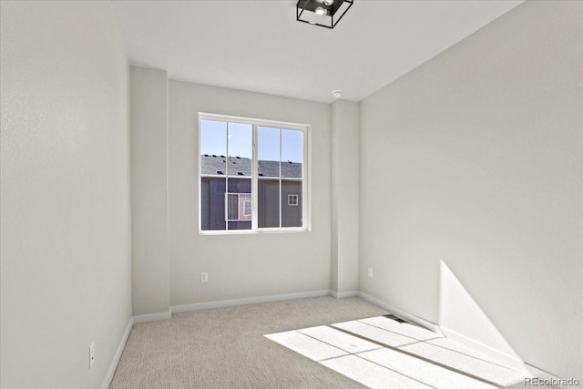 carpeted spare room featuring baseboards