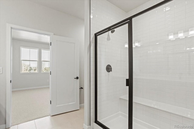 bathroom featuring tile patterned floors, baseboards, and a stall shower