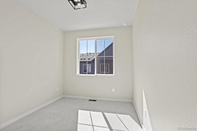 unfurnished room with visible vents, baseboards, and carpet