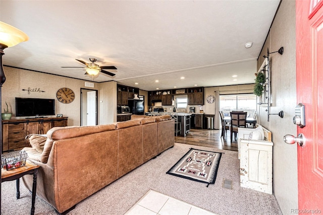 living area featuring light carpet, recessed lighting, and a ceiling fan