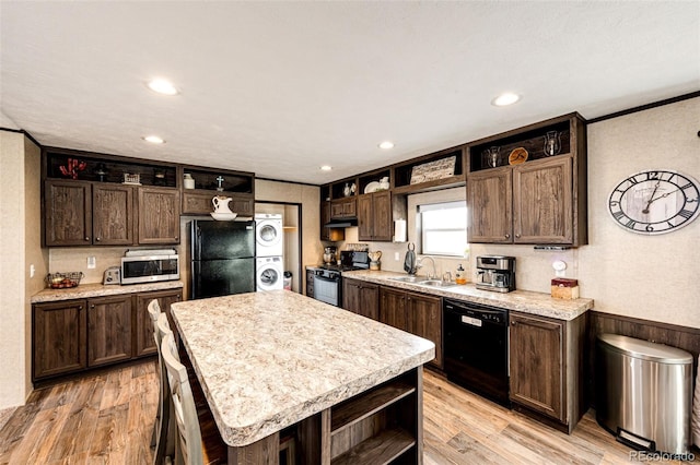kitchen featuring open shelves, black appliances, stacked washer and clothes dryer, dark brown cabinetry, and ornamental molding