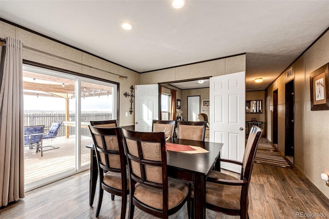 dining room featuring wood finished floors and ornamental molding
