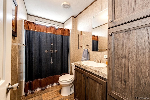 full bath with crown molding, wood finished floors, toilet, vanity, and curtained shower