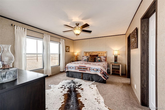 carpeted bedroom featuring crown molding and a ceiling fan