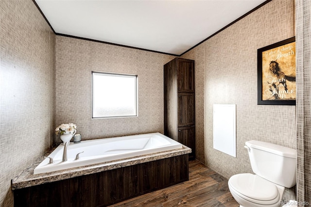 bathroom with crown molding, toilet, wood finished floors, and a garden tub