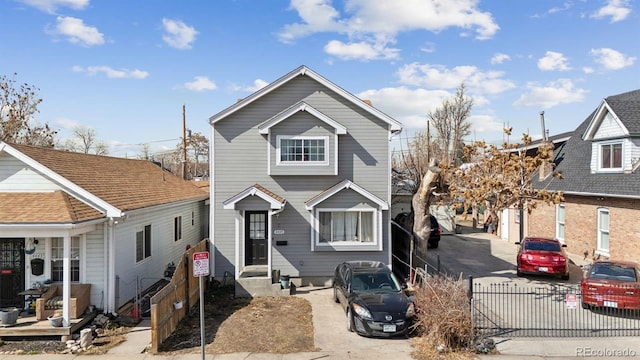 view of front of property featuring driveway and fence