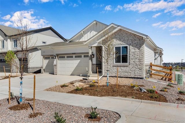 24593 E 34th Ave, Aurora, CO 80019 - view of front facade with board and batten siding, stone siding, an attached garage, and concrete driveway