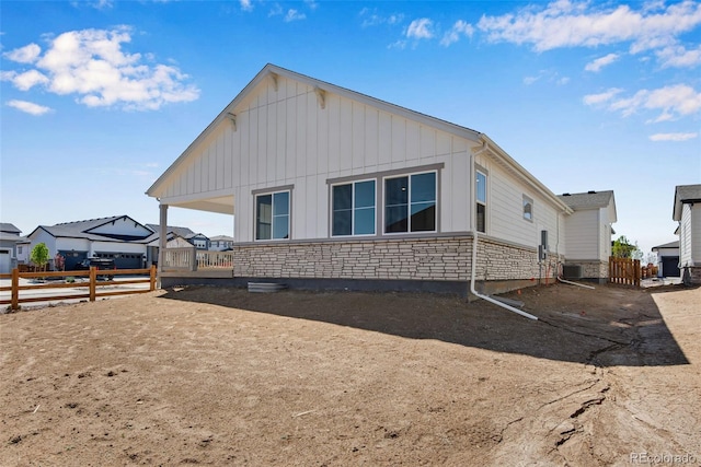 24593 E 34th Ave, Aurora, CO 80019 - back of house featuring board and batten siding, fence, and stone siding