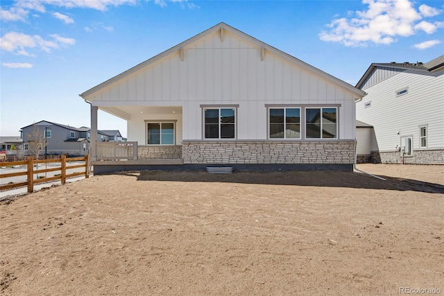 24593 E 34th Ave, Aurora, CO 80019 - back of house with board and batten siding, stone siding, and fence
