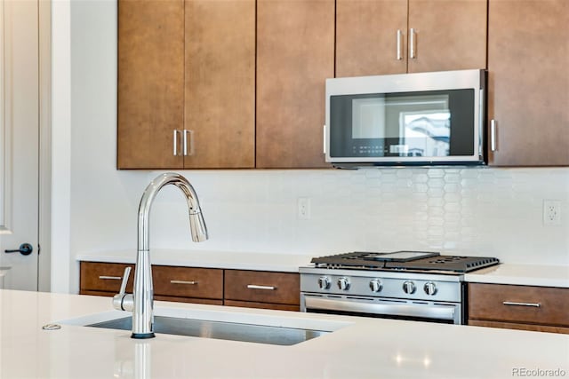 24593 E 34th Ave, Aurora, CO 80019 - kitchen featuring stainless steel appliances, a sink, light countertops, and tasteful backsplash