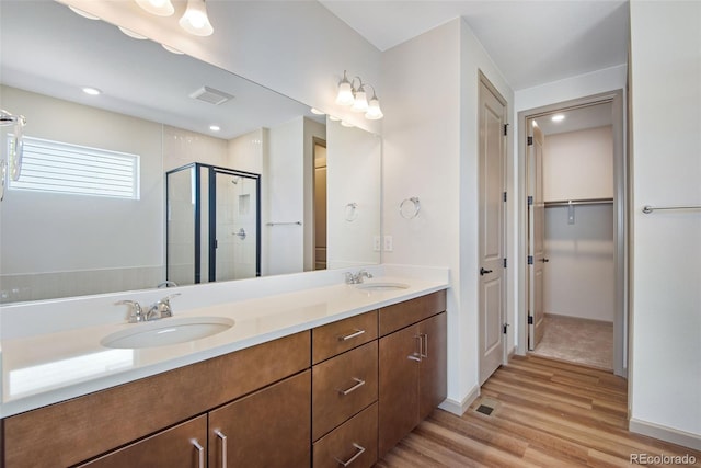 24593 E 34th Ave, Aurora, CO 80019 - full bathroom with a stall shower, wood finished floors, double vanity, a spacious closet, and baseboards