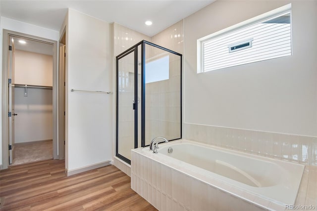 24593 E 34th Ave, Aurora, CO 80019 - bathroom featuring a stall shower, a bath, a walk in closet, wood finished floors, and recessed lighting
