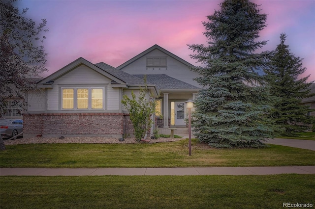 7831 S Addison Way, Aurora, CO 80016 - view of front facade featuring brick siding, a front lawn, and a shingled roof